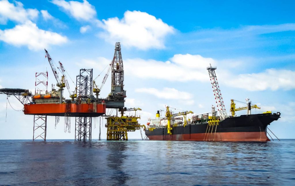 Offshore jack-up rig and tanker on calm sea